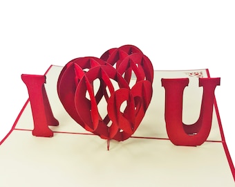 Puede incluir: Una tarjeta emergente roja con las palabras "Te amo" y un corazón 3D en el centro.