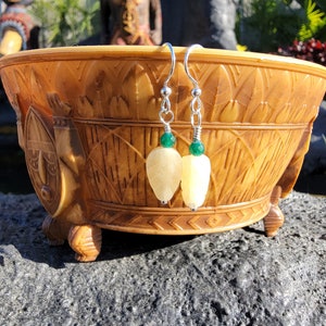 Könnte beinhalten: Ein Paar silberne Ohrringe mit weißen, blattartigen Anhängern und grünen Edelstein-Akzenten.