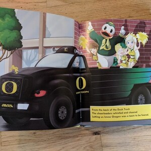 May include: A black truck with a large "O" for Oregon on the front grill. The truck is decorated with green and yellow accents. Cheerleaders are standing in the back of the truck, waving yellow pom-poms. The text "From the back of the Duck Truck The cheerleaders whistled and cheered Letting us know Oregon was a team to be feared." is printed below the image.