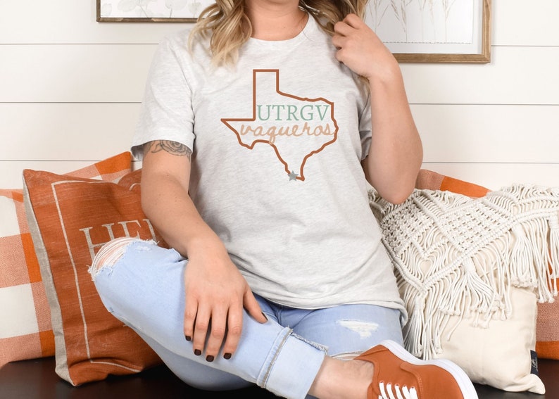 Pu&ograve; includere: T-shirt grigio chiaro con un contorno marrone dello stato del Texas e la scritta "UTRGV Vaqueros" in verde e marrone. La maglietta &egrave; realizzata in materiale morbido.