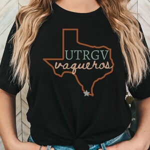Pu&ograve; includere: T-shirt nero con un disegno del contorno del Texas e la scritta "UTRGV Vaqueros". Il design &egrave; multicolore, con una stella e un contorno marrone. Una t-shirt casual per i fan.