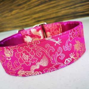 May include: A pink dog collar with a gold floral and dragon pattern.