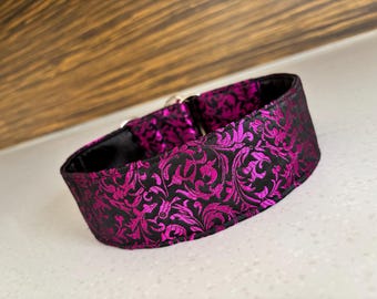 May include: A black and magenta patterned dog collar with a silver buckle.