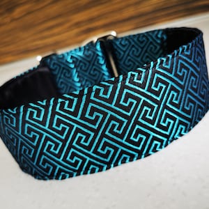 May include: A black and turquoise dog collar with a geometric pattern.