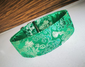 May include: A green dog collar with a silver buckle and a dragon and floral pattern.
