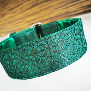 May include: A green dog collar with a patterned design. The collar is made of a soft, durable material and has a secure buckle closure.