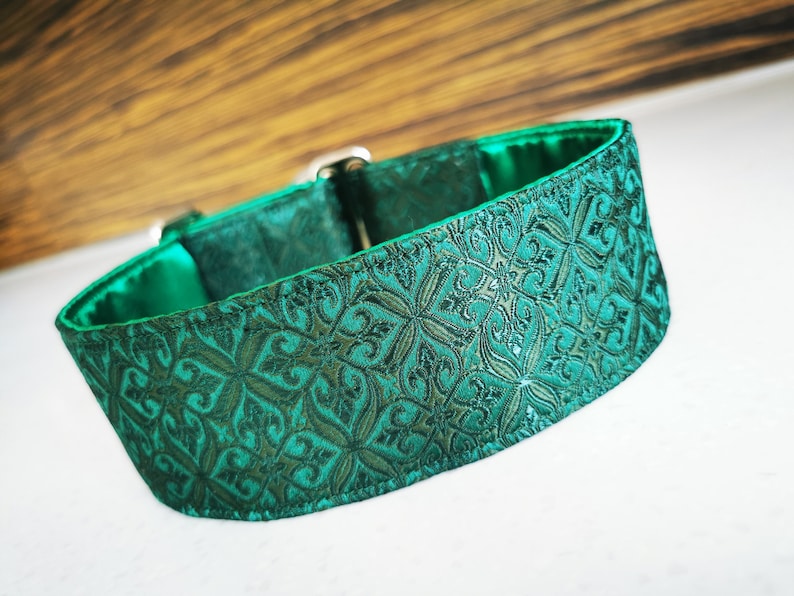 May include: A green dog collar with a patterned design. The collar is made of a soft, durable material and has a secure buckle closure.