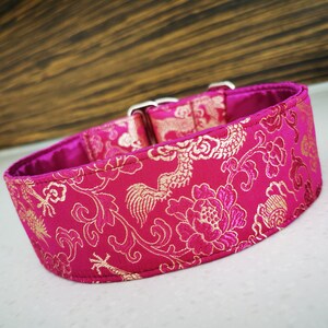 May include: A pink dog collar with a gold floral and dragon pattern.