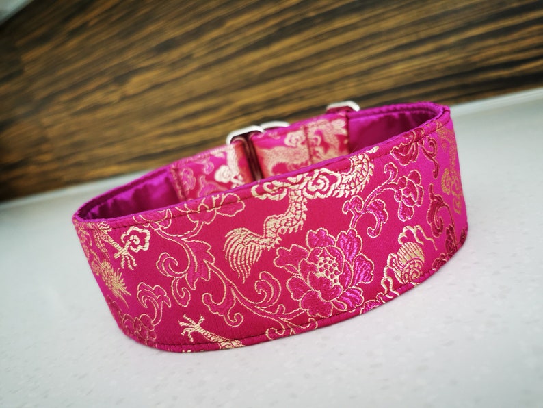 May include: A pink dog collar with a gold floral and dragon pattern.