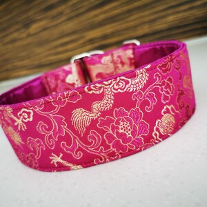 May include: A pink and gold dog collar with a floral pattern. The collar is made of a soft, luxurious fabric and features a silver buckle.