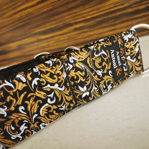Puede incluir: Collar para perro negro y dorado con estampado, herrajes plateados y el texto "Amal & Antoni" en la correa.