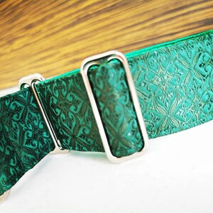 May include: A green patterned dog collar with a silver buckle. The collar is made of a soft, durable material and is designed to be comfortable for dogs of all sizes.