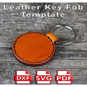 Puede incluir: Plantilla de llavero redondo de cuero naranja con borde cosido y llavero plateado. El texto "Leather Key Fob Template" está en la parte superior. Debajo hay iconos para los formatos de archivo DXF, SVG y PDF.