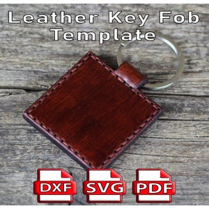 Op de afbeelding: Een donkerbruine leren sleutelhanger sjabloon met een zilveren sleutelring. De vierkante sleutelhanger heeft gestikte randen en de tekst "Leather Key Fob Template" staat bovenaan. Hieronder staan iconen voor DXF-, SVG- en PDF-bestanden.