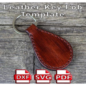 Puede incluir: Plantilla de llavero de cuero marrón con un llavero plateado. El llavero tiene forma de lágrima y bordes cosidos. El texto "Leather Key Fob Template" está en la parte superior. Debajo se muestran iconos para archivos DXF, SVG y PDF.