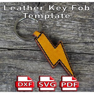 May include: A leather key fob template in the shape of a yellow lightning bolt with a silver key ring. The text "Leather Key Fob Template" is at the top. Below are icons for DXF, SVG, and PDF files.