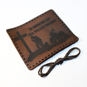 Op de afbeelding: Bruin leren patch met een kruis, een knielende figuur en een motorfiets. De patch heeft de tekst "In Memory of All Fallen Bikers".