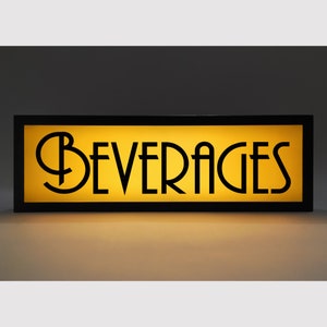 May include: A rectangular sign with the word "BEVERAGES" in black, Art Deco-style lettering. The sign has a yellow illuminated background and a black frame. The sign is designed to be mounted.