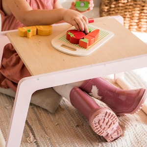 small children table with pink legs girl sitting on the desk