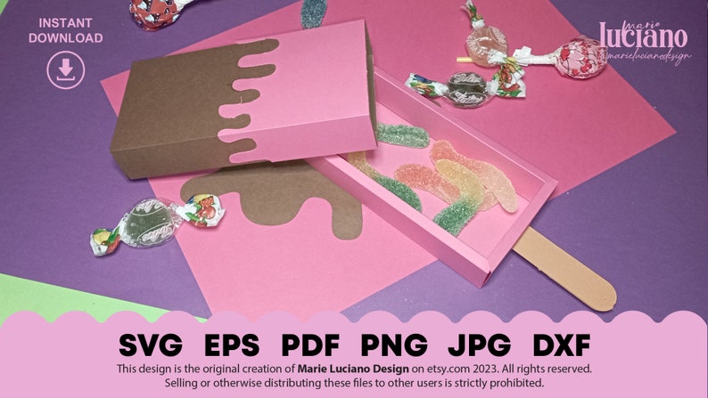 May include: A pink and brown popsicle-shaped box with a lid. The box is open and filled with gummy candies. The box is sitting on a purple surface.