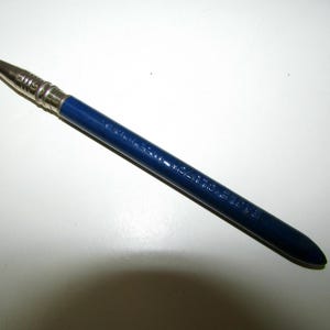 Puede incluir: Un lápiz azul vintage con punta y virola de metal plateado. El lápiz tiene el texto "EAGLE CLUTCH 1357" impreso en el lateral. Es una herramienta de escritura.