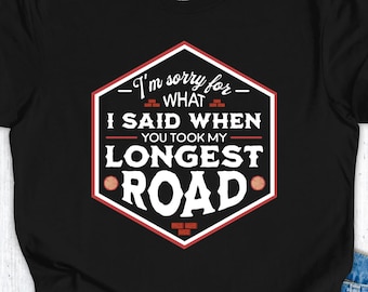 Op de afbeelding: Zwart T-shirt met een witte en rode afbeelding. De afbeelding luidt: "Het spijt me voor wat ik zei toen je mijn langste weg nam."