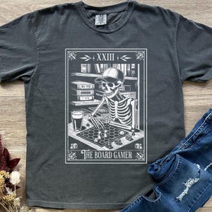 Camiseta unisex teñida con diseño de esqueleto de cartas del tarot de The Board Gamer de Comfort Colors, para Halloween, para una noche de juegos de mesa, regalo para un fanático de los juegos de mesa