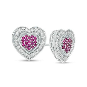 Puede incluir: Un par de pendientes de botón en forma de corazón hechos de metal plateado. Cada pendiente presenta un grupo central de pequeñas piedras de color rosa vibrante rodeado por un doble halo de diminutas piedras blancas transparentes, creando un diseño de corazón en capas.