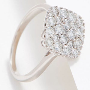 Puede incluir: Un anillo de plata con un engaste cuadrado lleno de pequeños diamantes brillantes.