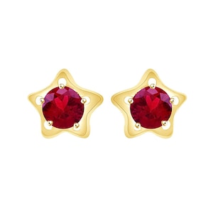 May include: A pair of gold star-shaped earrings with red gemstone accents.