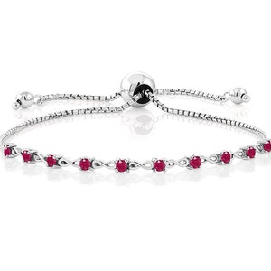 Puede incluir: Un brazalete ajustable de plata con un diseño de cadena y piedras preciosas rojas. El brazalete tiene un cierre deslizante.