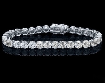 May include: A silver tennis bracelet with a row of round, clear diamonds.