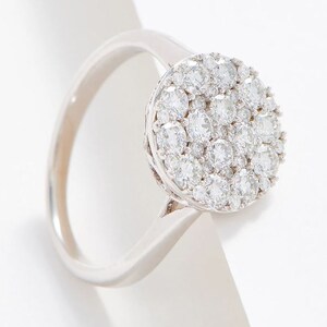 Puede incluir: Un anillo de plata con un gran racimo redondo de pequeños diamantes.