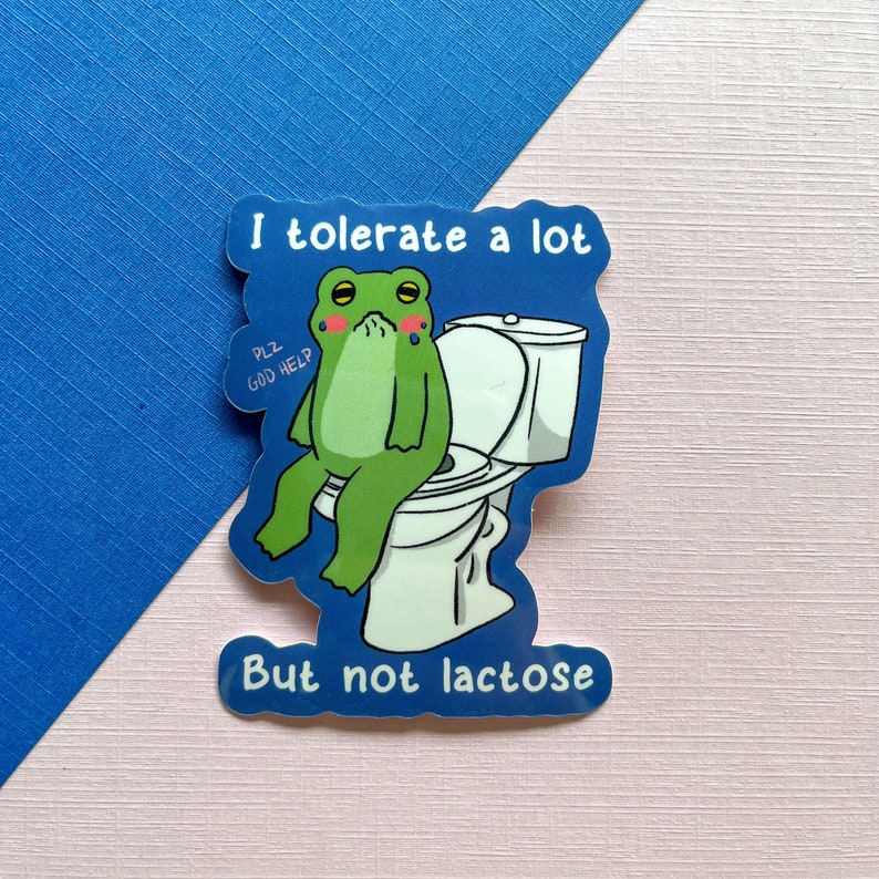 Pu&ograve; includere: Un adesivo blu con una rana di cartone animato seduta su un water. La rana &egrave; verde e ha un'espressione triste. L'adesivo dice "Toller&ograve; molto ma non il lattosio".