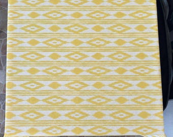 Könnte beinhalten: Eine rechteckige Tischdecke mit einem sich wiederholenden horizontalen Muster aus gelben und weißen Rauten, durchsetzt mit dünnen, strukturierten gelben und weißen horizontalen Streifen, die ein konsistentes geometrisches Design bilden.