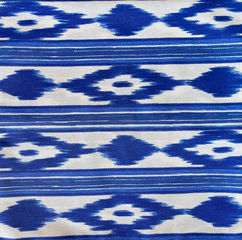 K&ouml;nnte beinhalten: Blauer und wei&szlig;er Ikat-Stoff mit einem sich wiederholenden geometrischen Muster.