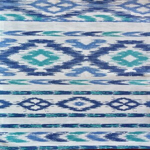 K&ouml;nnte beinhalten: Wei&szlig;er Stoff mit einem blauen und gr&uuml;nen geometrischen Muster. Das Muster besteht aus sich wiederholenden Rauten und Streifen.