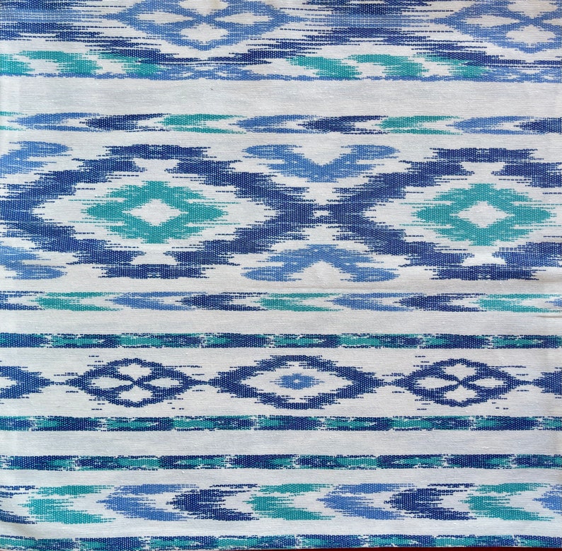 K&ouml;nnte beinhalten: Wei&szlig;er Stoff mit einem blauen und gr&uuml;nen geometrischen Muster. Das Muster besteht aus sich wiederholenden Rauten und Streifen.