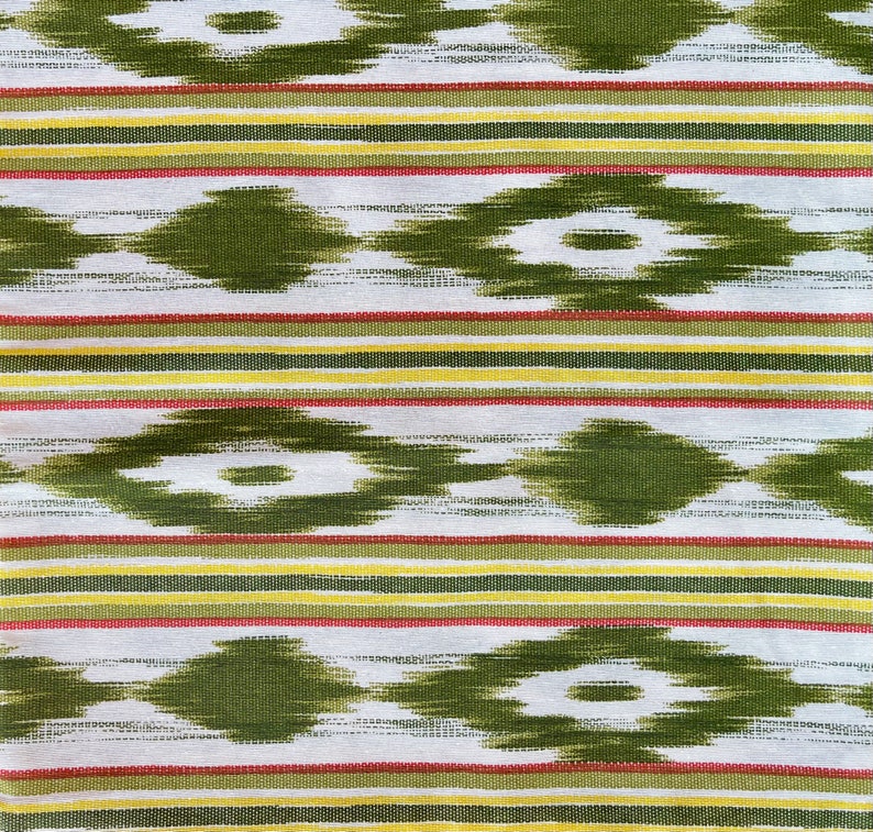 K&ouml;nnte beinhalten: Gr&uuml;n-wei&szlig; gestreiftes Gewebe mit einem sich wiederholenden Rautenmuster. Der Stoff hat eine subtile Textur und einen leicht verblassten Look.
