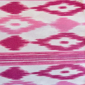 Puede incluir: Tela ikat rosa y blanca con un patr&oacute;n repetido de diamantes y rayas.