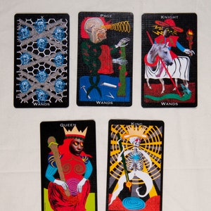 Puede incluir: Un conjunto de diez cartas de tarot que representan el palo de Bastos. Las cartas son negras con ilustraciones coloridas. Las cartas incluyen el Paje, el Caballero, la Reina, el Rey y el Diez de Bastos.