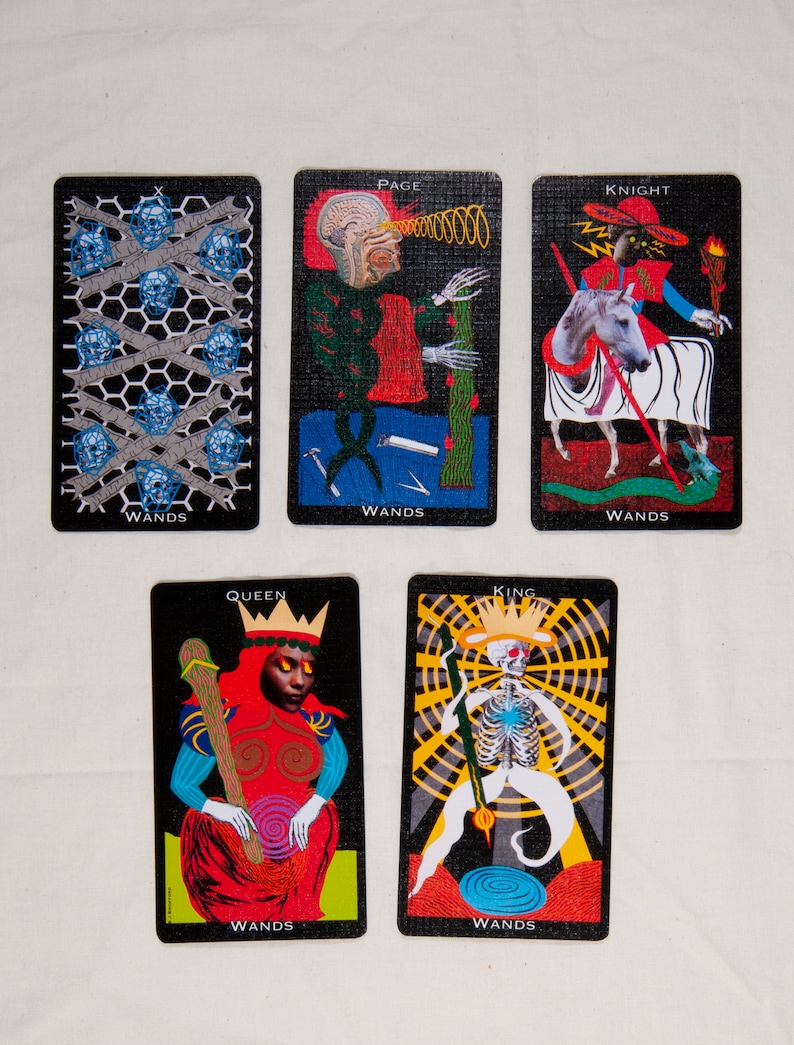 Puede incluir: Un conjunto de diez cartas de tarot que representan el palo de Bastos. Las cartas son negras con ilustraciones coloridas. Las cartas incluyen el Paje, el Caballero, la Reina, el Rey y el Diez de Bastos.