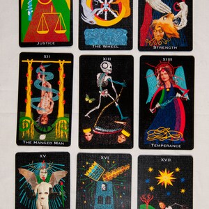 Puede incluir: Un juego de 10 cartas de tarot con fondos negros e ilustraciones coloridas. Las cartas est&aacute;n numeradas VIII, X, XI, XII, XIII, XIV, XV, XVI, XVII y XVIII. Las cartas representan diversas figuras y s&iacute;mbolos, incluyendo una calavera, una rueda, una mujer con un le&oacute;n, un hombre ahorcado, un esqueleto, una mujer con una copa, un diablo, una torre, una estrella y una luna.