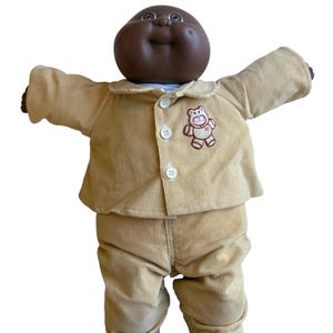 May include: A white ceramic mug with a black handle and the text "But First, Coffee" in a black, bold font. The mug is on a white surface.