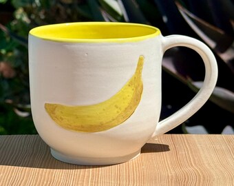 Taza amarilla y blanca de 414 ml con diseño de plátano, hecha a mano en California. ¡Un plátano en cada lado!