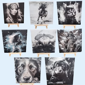 May include: A selection of square canvas art prints, each with a monochrome illustration. The images depict a woman, a running horse, a kitten, a woman with energy, a gnome, a grim reaper, a dog, and a puppy. Each print is displayed on a small wooden easel.