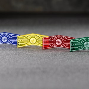 May include: Four plastic tokens in blue, yellow, red, and green. Each token features a white design of a stylised globe with lines radiating outwards.