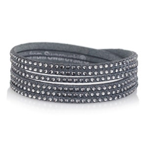 Op de afbeelding: Een grijze leren wikkelarmband met meerdere rijen glinsterende grijze kristallen.