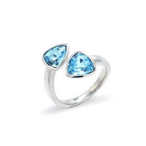 Puede incluir: Un anillo de plata con dos piedras azules triangulares. El anillo es abierto y tiene un diseño simple.