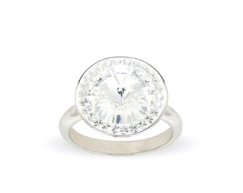May include: A silver ring with a large, clear, round crystal surrounded by a halo of smaller crystals.